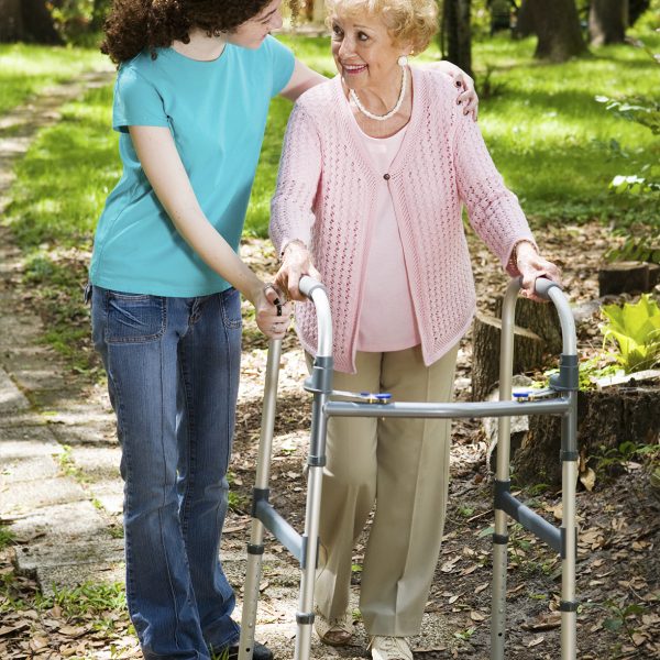 Senior woman and her teen granddaughter taking a walk in the park.